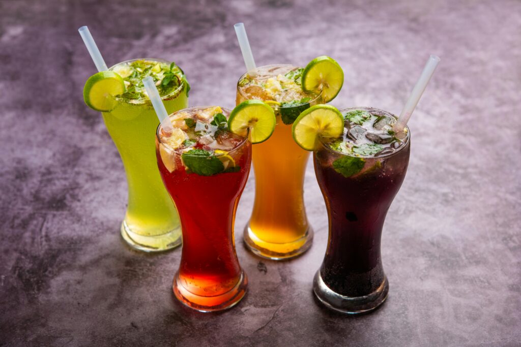 Bright and colorful cocktails with citrus garnish on a black background.